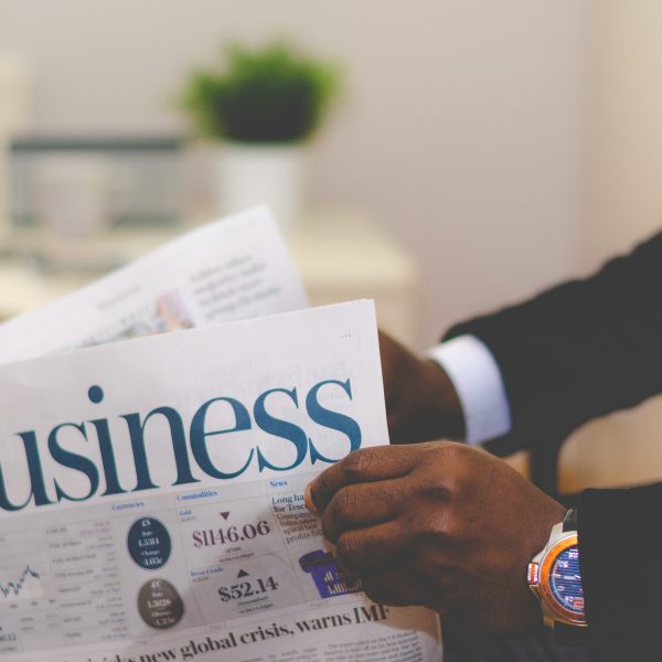 Man holding the business section of the newspaper.