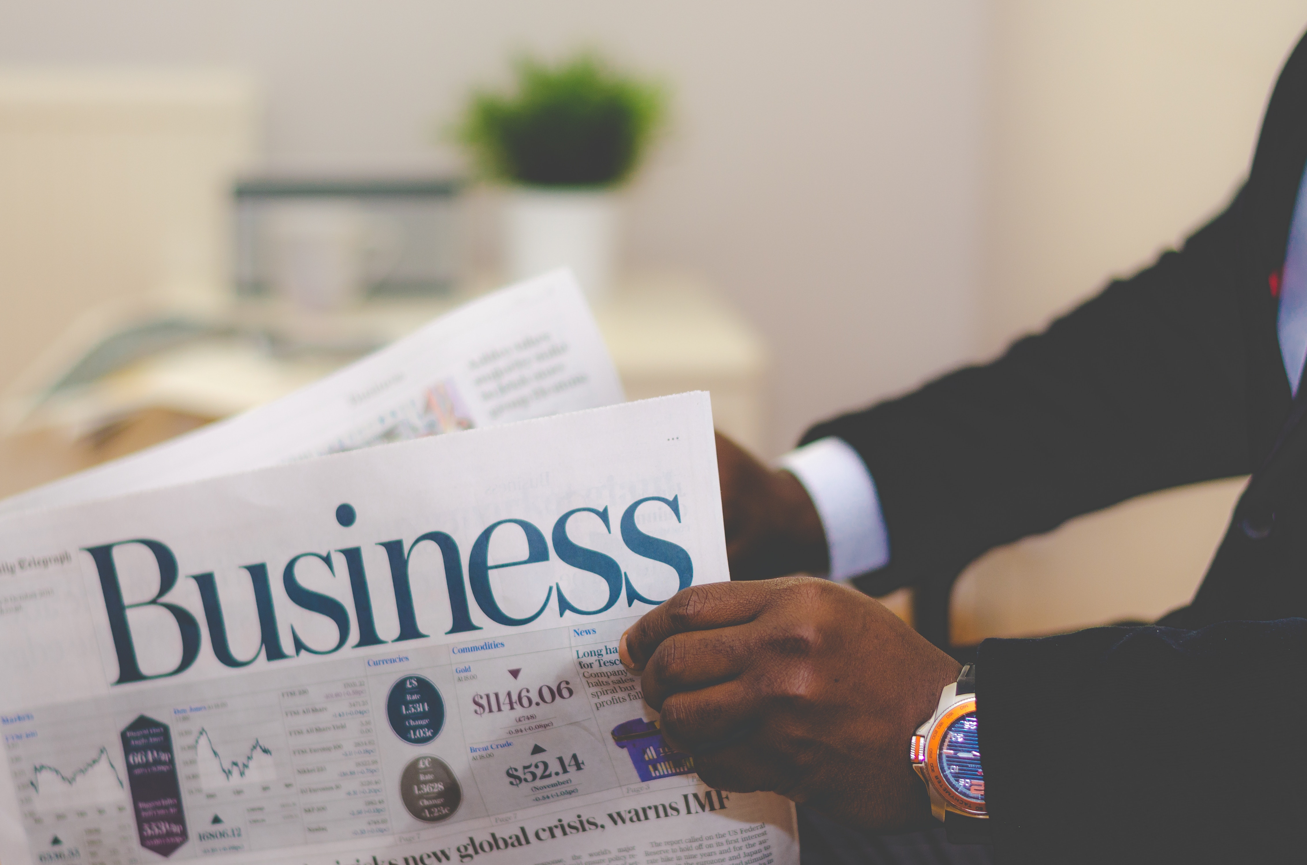 Man holding the business section of the newspaper.